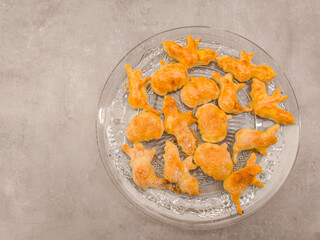 Halloween cookies shaped like bats, pumpkins and cats resting on glass plate, copy space