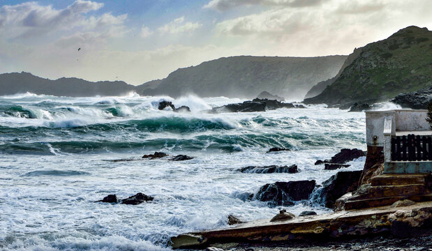 Temporal en el mar Menorca olas salpicando sobre las rocas viento de tramontana