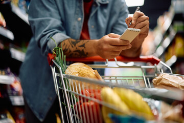 Close up of man with shopping list at the store.
