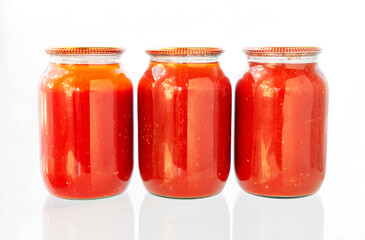 Jars of tomato juice. Canned tomato Juice prepared at home in glass, on isolated white background.