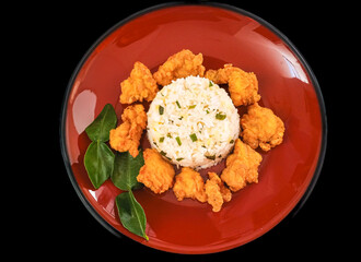 Nasi Ayam Crispy Daun Jeruk or crispy fried chicken with lime leaves rice is served on red plate...