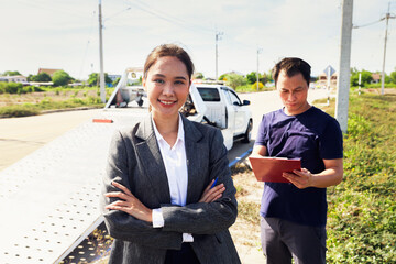 Female officer from car insurance company stands crosses her arms help take care damaged car and...