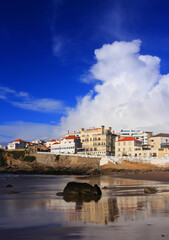 Fototapeta premium Panoramic view and dramatic sky over the picturesque seaside town and the beach of Praia das Macas, Sintra, Portugal. 