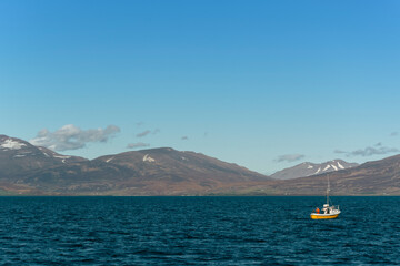 Fishing boat on the ocean with mountains in the background, Iceland