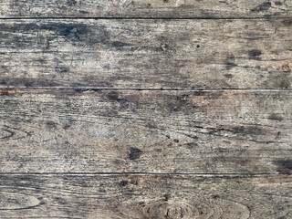 Close up of weathered and rustic solid wood texture with black veins. Weathered textured timber wooden plank and deck in industrial vintage color. Seamless background texture.