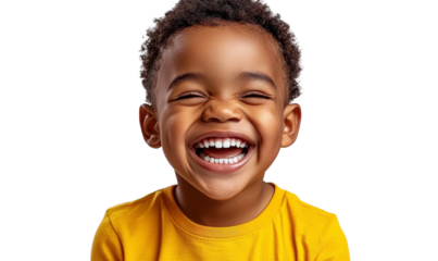 Joyful young child with curly hair happily smiling in a bright yellow shirt on a black background expressing pure happiness and carefree innocence