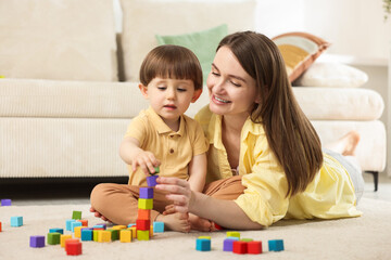 Mother and son playing with colorful cubes at home