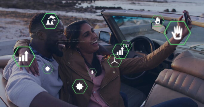 Smiling couple taking selfie with smartphone in convertible interior at rocky shore, with overlays