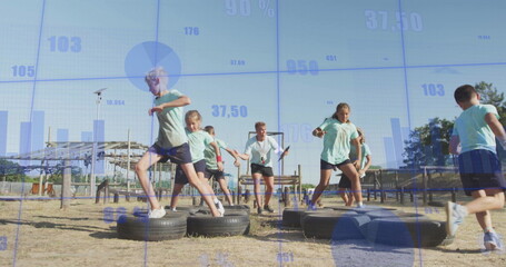 Instructor and children in sportswear stepping through tire obstacle course at park, with tires