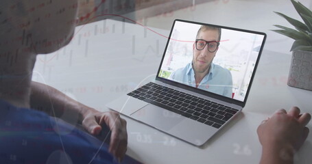 Worker sitting at home desk viewing man in shirt on laptop, with mouse and chart graphics