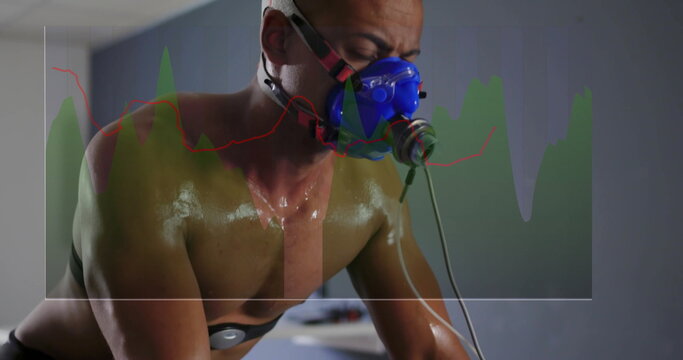 Cycling adult male leaning over bike handlebars in clinical lab, with mask tubing electrodes graph