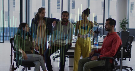Gathering office team discussing bar chart overlay in open-plan office with desks and swivel chairs