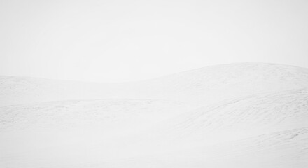 Minimalist Snowy Landscape Depicting Rolling Hills Under a Vast Overcast Sky in a Gentle Winter Scene