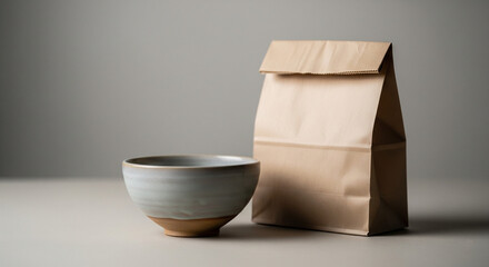 Minimal ceramic bowl and paper bag arrangement on neutral surface 