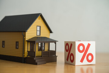 House model and interest rate box (percentage sign). Mortgage loan, burden payment from high interest rate, FED central bank control monetary policy, financial risk management, home finance concept.