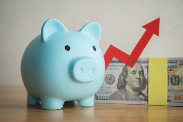 Blue piggy bank, US dollar banknotes with red growth chart. Wealth and money management, money saving, personal financial planning, return on investment, savings for retirement and so on concept.