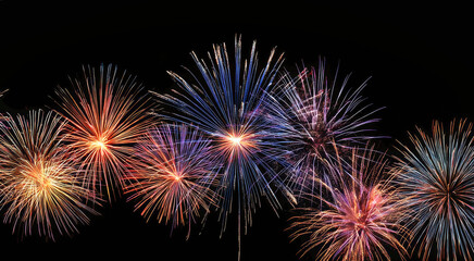 Obraz premium Fireworks illuminate the dark night sky, celebrating joyous occasions and creating a vibrant festive atmosphere