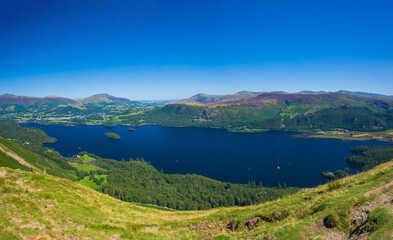 Panoramic view of Derwentwater and surrounding green mountains from the summit of Catbells on a clear summer day (Keswick, Lake District, England, United Kingdom)