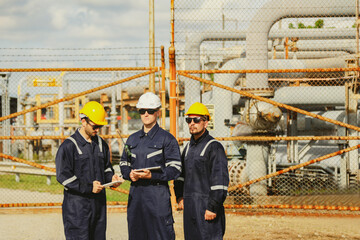 Team male engineers and technicians stand consulting on the road in front entrance oil , gas...