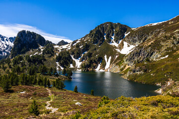 Blue Lake at the foot of Sarrat de Gabensa and Roc de Bragues in spring, with the last snow