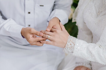 Groom wear wedding rings to left finger of bride, Muslim wedding, malaysia , Indonesia ,Wedding Poster, Close up hand.	