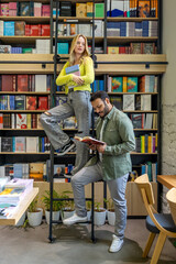 Multicultural man and woman working in library