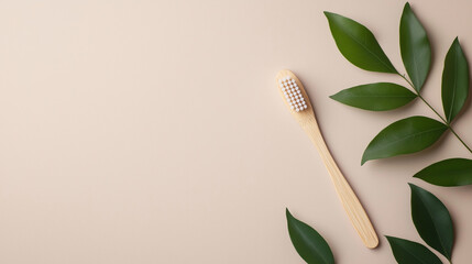 Natural bamboo toothbrush resting on a soft beige background with green leaves nearby