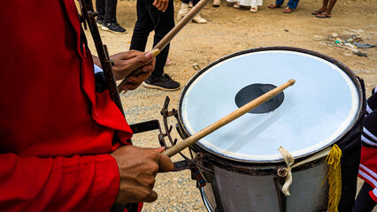 hand holding a beater and drum percussion instrument