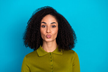 Charming Woman Posing with a Kiss Gesture Wearing Green Outfit Against a Blue Background in a Fun...