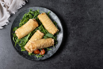 Crispy vegetables spring Rolls on black background. Top view. Copy space