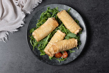 Crispy vegetables spring Rolls on black background. Top view