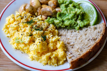 Scambled Eggs With Mashed Avacado Fried Musherooms and Seeded Bread