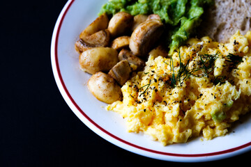 Scambled Eggs With Mashed Avacado Fried Musherooms and Seeded Bread