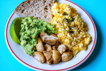 Scambled Eggs With Mashed Avacado Fried Musherooms and Seeded Bread