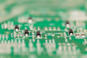 Macro close-up of surface-mount transistors on a green printed circuit board, showing electronic...