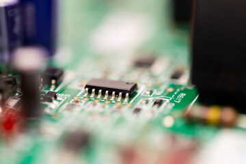 Macro shot of an integrated circuit (IC) chip with visible solder joints on a green printed circuit...