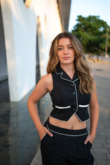 Young stylish woman posing with hands in pockets in urban setting