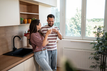 Happy couple toasting with milk in modern kitchen