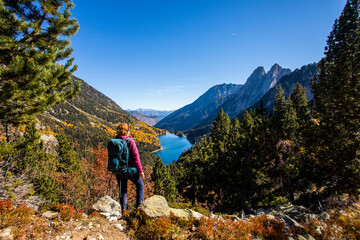 Young hiker woman in autumn in Aiguestortes and Sant Maurici National Park, Spain