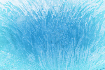 Abstract of water surface with ripples and light reflections, creating a dynamic and refreshing blue texture.