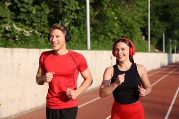 Sporty couple running at stadium. Healthy lifestyle