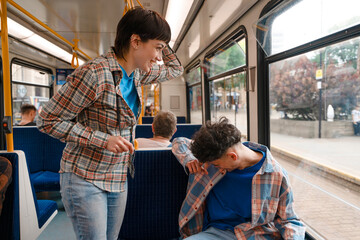 Two friends enjoying a lively conversation while traveling on a city bus during the day, capturing...