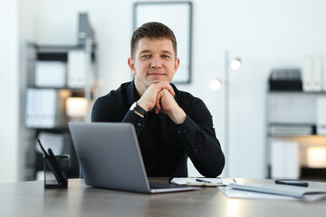 Portrait of handsome man at desk in office