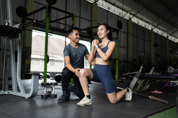 Fitness Coaching and Support. Personal trainer assisting a young woman with her workout routine.
