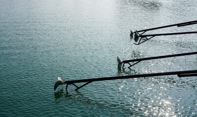 Close up of a long tail boat propeller above water.