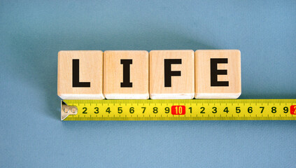 Life symbol. Concept word Life on beautiful wooden blocks. Beautiful yellow ruler. Beautiful blue...