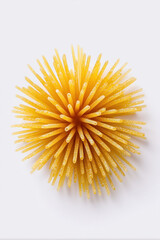 A top-down shot of yellow spaghetti in the shape of an Italian star, centered on a white background