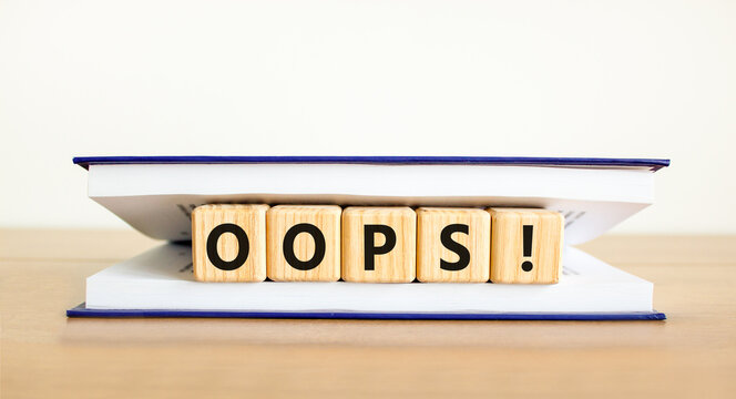 Oops symbol. Concept word Oops on beautiful wooden blocks in book. Beautiful wooden table white background. Business lifestyle oops concept. Copy space.