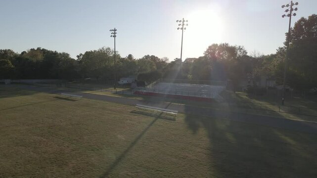 Empty sports field at sunset with bright sky