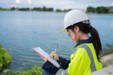 Environmental engineers work at the water storage plant, check the pH of the water, check the...